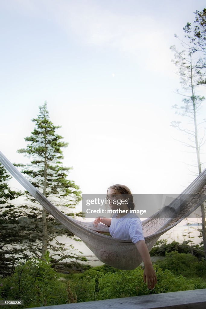 Young girl daydreaming in hammock