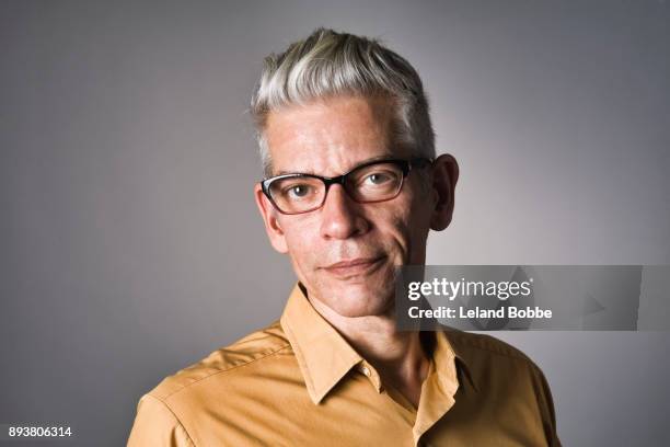 portrait of cool looking middle aged man with grey hair - yellow shirt stock pictures, royalty-free photos & images