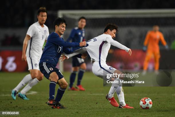 Jung Wooyoung of South Korea controls the ball under pressure of Yasuyuki Konno of Japan during the EAFF E-1 Men's Football Championship between...