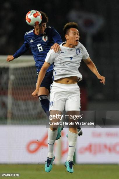 Genta Miura of Japan and Kim Shinwook of South Korea compete for the ball during the EAFF E-1 Men's Football Championship between Japan and South...