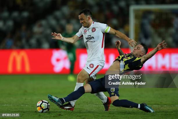 Mark Bridge of the Wanderers contests the ball against Storm Roux of the Mariners during the round 11 A-League match between the Central Coast and...