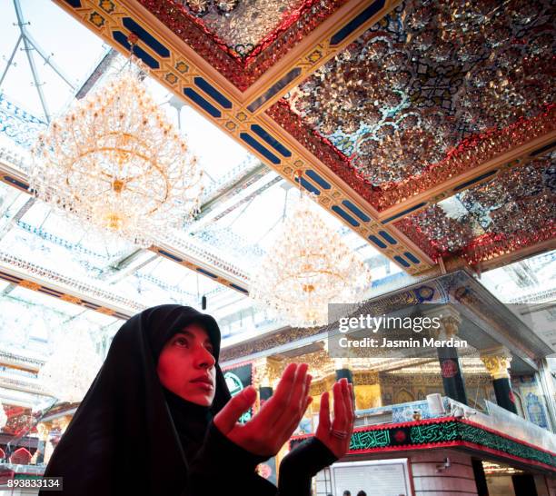 woman praying inside a mosque - shrine of the imam ali ibn abi talib stock pictures, royalty-free photos & images