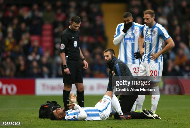 Elias Kachunga of Huddersfield Town receives treatment from the medical team during the Premier League match between Watford and Huddersfield Town at...