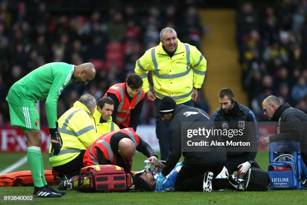 Elias Kachunga of Huddersfield Town receives treatment from the medical team during the Premier League match between Watford and Huddersfield Town at...