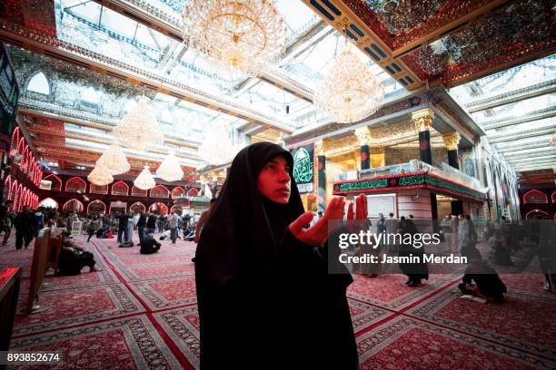 woman praying inside a mosque - shrine of the imam ali ibn abi talib stock-fotos und bilder