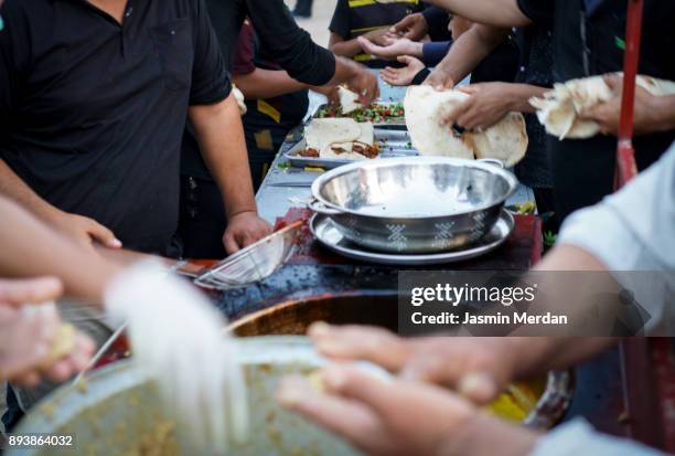 making traditional free street food distributed to people - refugee camp imagens e fotografias de stock