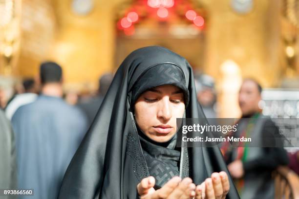 woman praying inside a mosque - shrine of the imam ali ibn abi talib stock-fotos und bilder