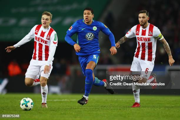 Jeffrey Bruma of Wolfsburg gets past the tackle from Tim Handwerker and Marco Hoger of FC Koeln during the Bundesliga match between 1. FC Koeln and...