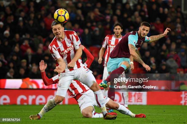 Marko Arnautovic of West Ham United shoots as Kevin Wimmer of Stoke City attempts to block during the Premier League match between Stoke City and...