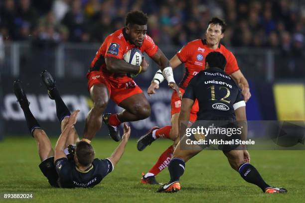 Tuisova Josua of Toulon leaps over the challenge of Rhys Priestland of Bath as Ben Tapuai closes in during the European Rugby Champions Cup match...