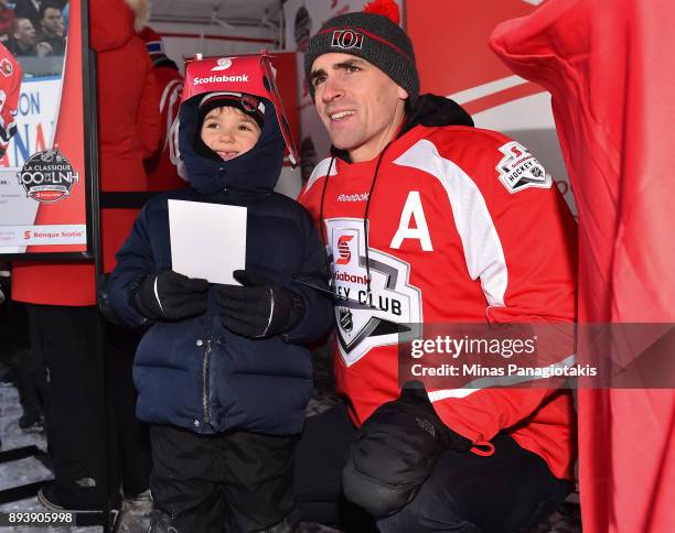 Ottawa Senators alumni Wade Redden poses for a photo with a young fan during the 2017 Scotiabank NHL100 Classic at Lansdowne Park on December 16,...