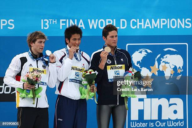 Helge Meeuw of Germany celebrates the silver medal, Junya Koga of Japan the gold medal and Aschwin Wildeboer of Spain the bronze medal during the...