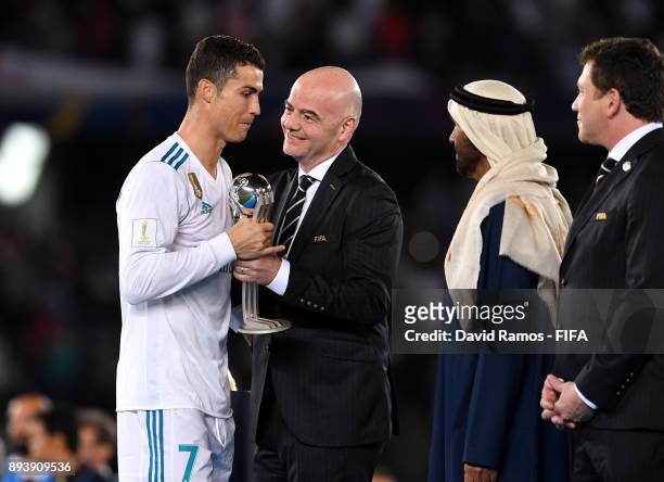President Gianni Infantino presents Cristiano Ronaldo of Real Madrid with the trophy after the FIFA Club World Cup UAE 2017 Final between Gremio and...