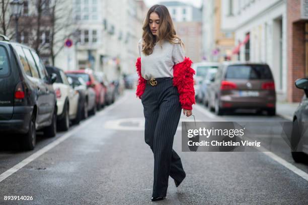 Anna Sharypova wearing Gucci belt, grey H&M turtleneck, red jacket &other stories, navy striped H&M pants, Zara bag, Buffalo heels on December 16,...