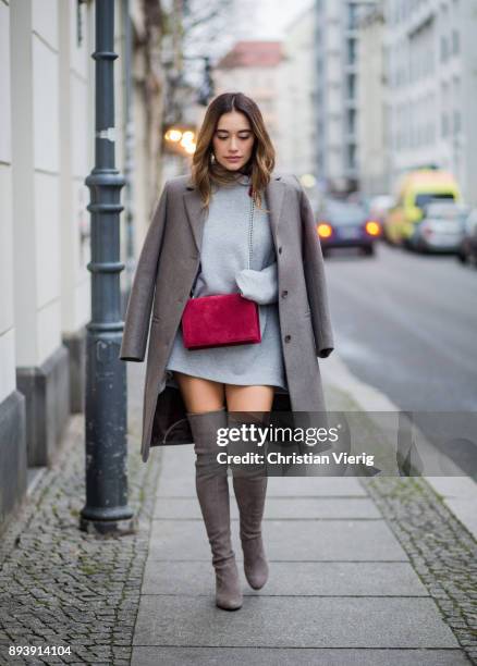 Anna Sharypova wearing Stuart Weitzman overknee boots, a grey COS coat, red Agneel bag, grey COS turtleneck on December 16, 2017 in Berlin, Germany.