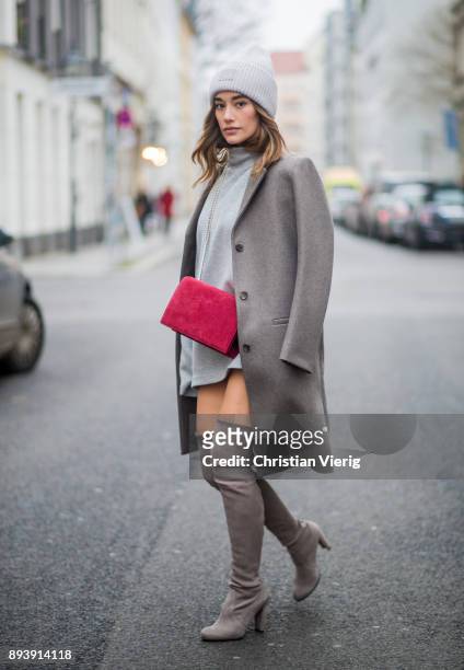 Anna Sharypova wearing Stuart Weitzman overknee boots, a grey COS coat, red Agneel bag, grey COS turtleneck on December 16, 2017 in Berlin, Germany.