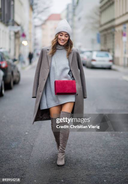 Anna Sharypova wearing Stuart Weitzman overknee boots, a grey COS coat, red Agneel bag, grey COS turtleneck on December 16, 2017 in Berlin, Germany.