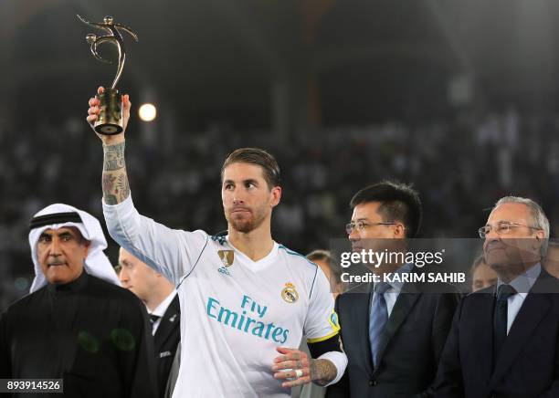 Real Madrid's Spanish defender and captain Sergio Ramos holds up the FIFA Fair Play Award next to Real Madrid President Florentino Perez following...
