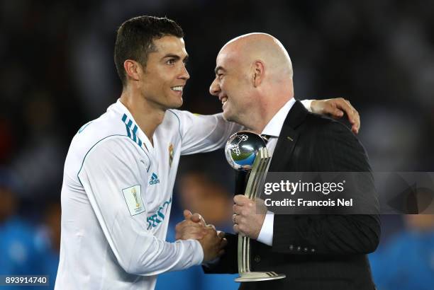 Cristiano Ronaldo of Real Madrid collects his adidas Golden Ball trophy from Gianni Infantino during the FIFA Club World Cup UAE 2017 Final between...