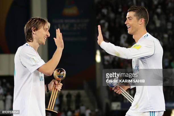 Real Madrid's Portuguese forward Cristiano Ronaldo holding his 2017 FIFA Club World Cup Silver Ball award celebrates with his teammate Luka Modric...