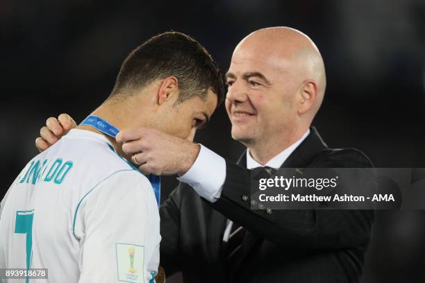 Cristiano Ronaldo of Real Madrid receives his winners medal from FIFA President Gianni Infantino at the end of the FIFA Club World Cup UAE 2017 final...