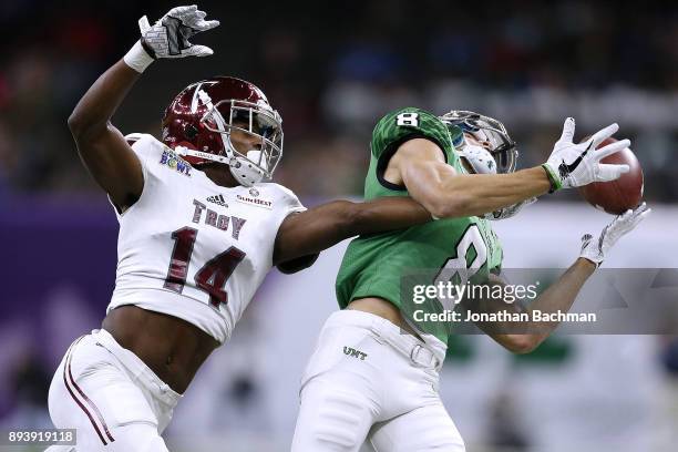 Terence Dunlap of the Troy Trojans breaks up a pass intended for Rico Bussey Jr. #8 of the North Texas Mean Green during the first half of the R+L...