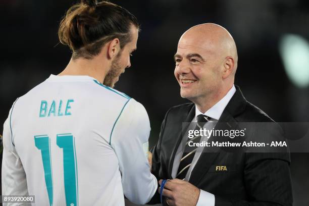 Gareth Bale of Real Madrid receives his winners medal from FIFA President Gianni Infantino at the end of the FIFA Club World Cup UAE 2017 final match...