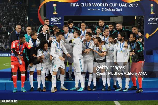 Sergio Ramos of Real Madrid receives the trophy from FIFA President Gianni Infantino at the end of the FIFA Club World Cup UAE 2017 final match...