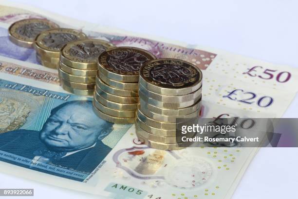 stacks of one pound coins on pound notes,£5,£10,£20,£50. - inflation stock pictures, royalty-free photos & images