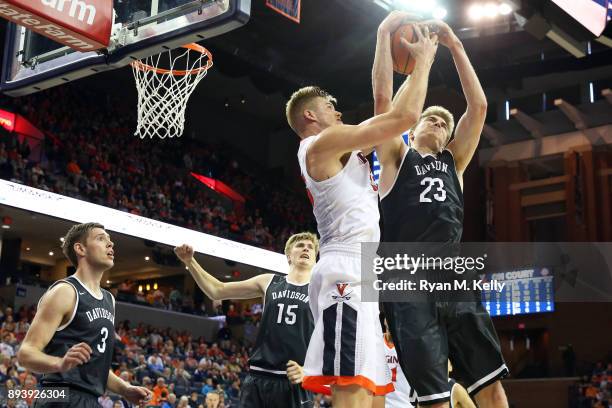 Jack Salt of the Virginia Cavaliers and Peyton Aldridge of the Davidson Wildcats fight for control of a rebound in the second half during a game at...