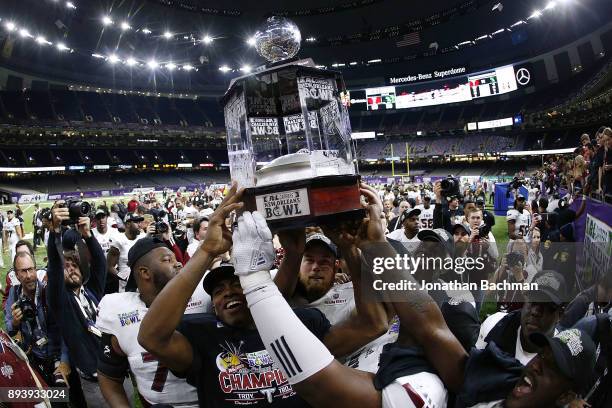 The Troy Trojans celebrate with the trophy after winning the R+L Carriers New Orleans Bowl against the North Texas Mean Green at the Mercedes-Benz...