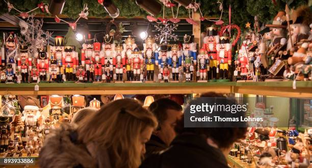 Visitors look at Christmas decorations at the annual Christmas market at Roemerberg on December 16, 2017 in Frankfurt, Germany. Christmas markets are...