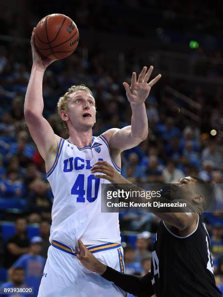 Thomas Welsh of the UCLA Bruins shoots over Kyle Washington of the Cincinnati Bearcats during the second half at Pauley Pavilion on December 16, 2017...