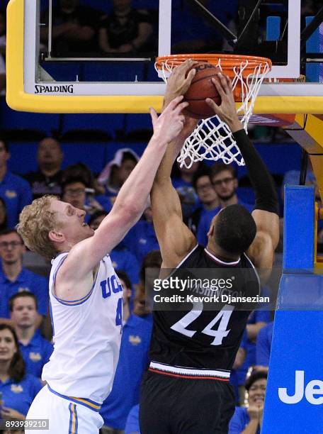 Thomas Welsh of the UCLA Bruins fouls Kyle Washington of the Cincinnati Bearcats as he goes up to score a basket during the second half at Pauley...