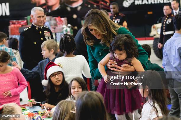 First Lady Melania Trump picks up 3-year-old Mehreem Donahue, as she sits down to make Christmas cards with military kids, at the Marine Corps'...