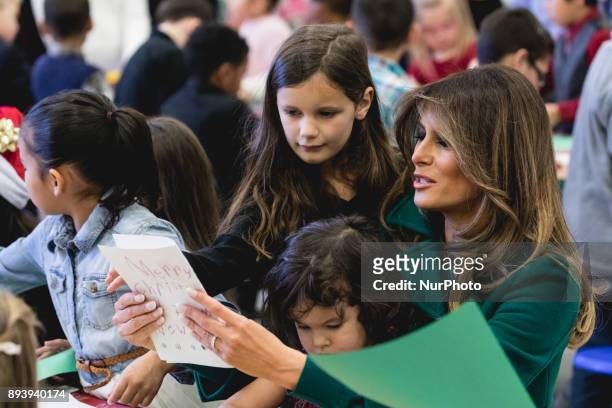 First Lady Melania Trump sits with 3-year-old Mehreem Donahue in her lap, as she makes Christmas cards with military kids, at the Marine Corps'...