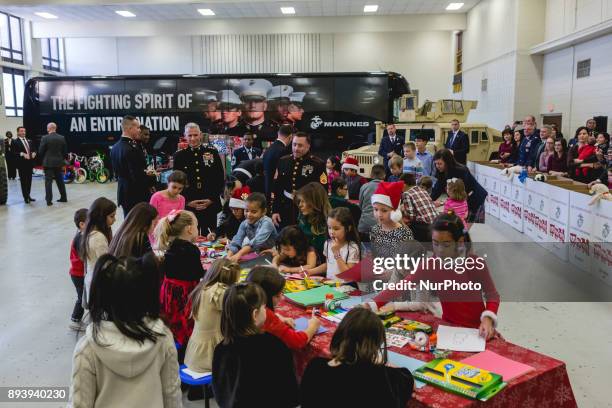 First Lady Melania Trump sits with 3-year-old Mehreem Donahue in her lap, as she makes Christmas cards with military kids, at the Marine Corps'...