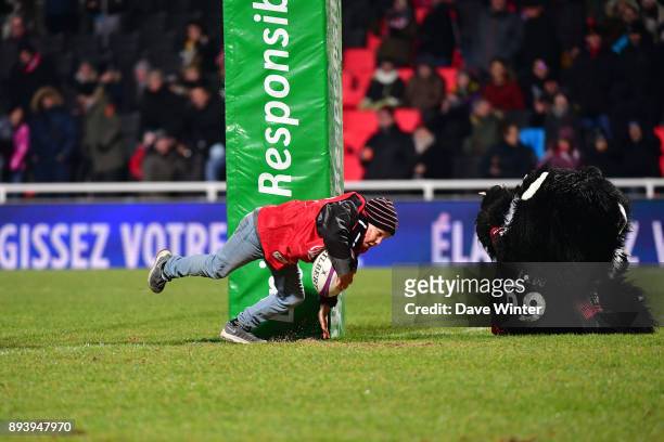 Half time entertainment sees children trying to score a try past the Lyon mascot during the European Rugby Challenge Cup match between Lyon OU and...