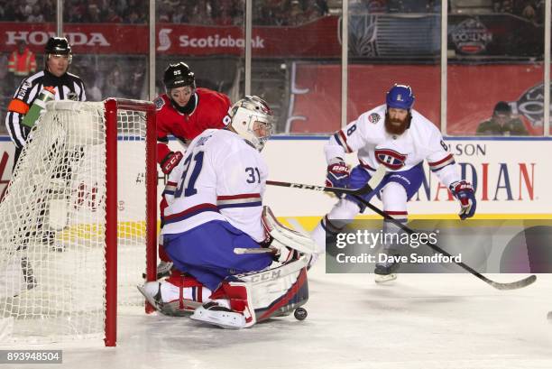 Carey Price of the Montreal Canadiens makes a pad save with with teammate Jordie Benn and Matt Duchene of the Ottawa Senators battling in front...