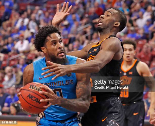 Florida State's Phil Cofer attempts to shoot as Oklahoma State's Tavarius Shine defends during the Orange Bowl Basketball Classic at the BB&T Center...