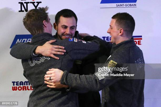 Olympic team nominees, from left, Tucker West, Chris Mazdzer and Taylor Morris hug during the Ice Ball at the Conference Center at Lake Placid on...