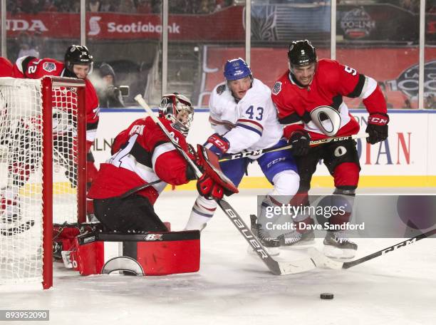 Daniel Carr of the Montreal Canadiens battles for a loose puck with Cody Ceci of the Ottawa Senators in front of teammate Craig Anderson during the...