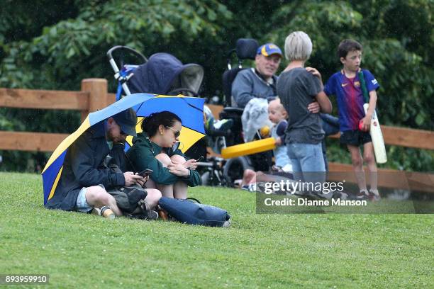 Supporters wait as rain delays play during the Twenty20 Supersmash match between Otago and Wellington on December 17, 2017 in Dunedin, New Zealand.