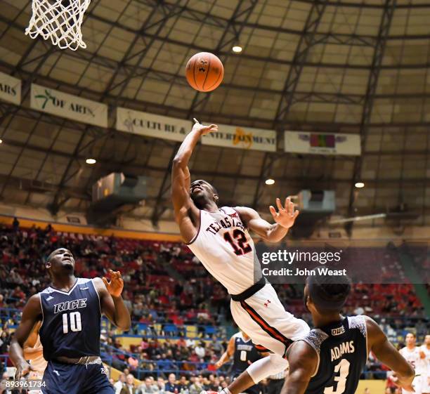 Keenan Evans of the Texas Tech Red Raiders shoots the ball against Ako Adams of the Rice Owls during the game on December 16, 2017 at Lubbock...