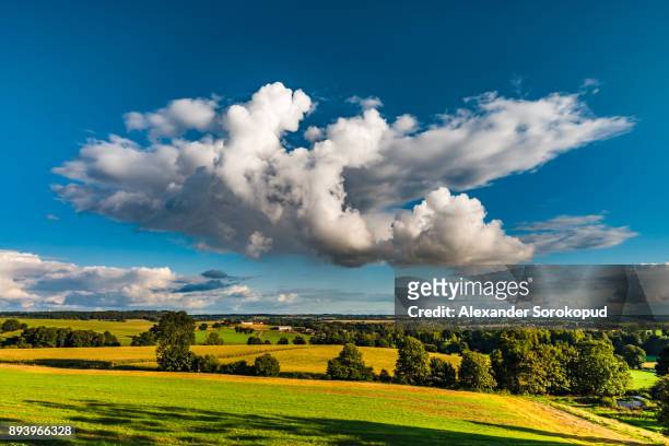 big white cloud over the colorful valley, sunset time, brittany, france - bretagne road landscape fotografías e imágenes de stock