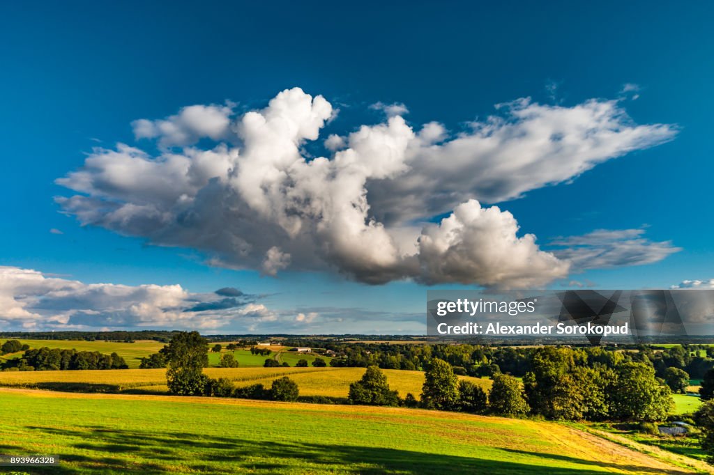 Big white cloud over the colorful valley, sunset time, Brittany, France