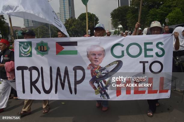 Indonesians march with a banner as they attend a protest against US President Donald Trump's recent decision to recognise Jerusalem as the capital...