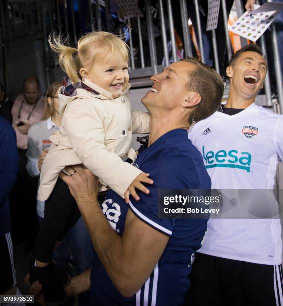 Stuart Holden holds up his daughter Kennady as Steve Nash looks on before the start of the Kick In For Houston Charity Soccer Match at BBVA Compass...