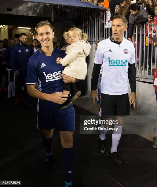 Stuart Holden, left, holding daughter Kennady and Steve Nash await to be introduced during the Kick In For Houston Charity Soccer Match at BBVA...