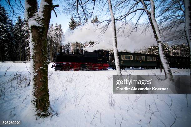 Steam powered locomotive of the Harz Narrow Gauge Railways travels through snow towards the station Brocken on December 16, 2017 in Wernigerode,...
